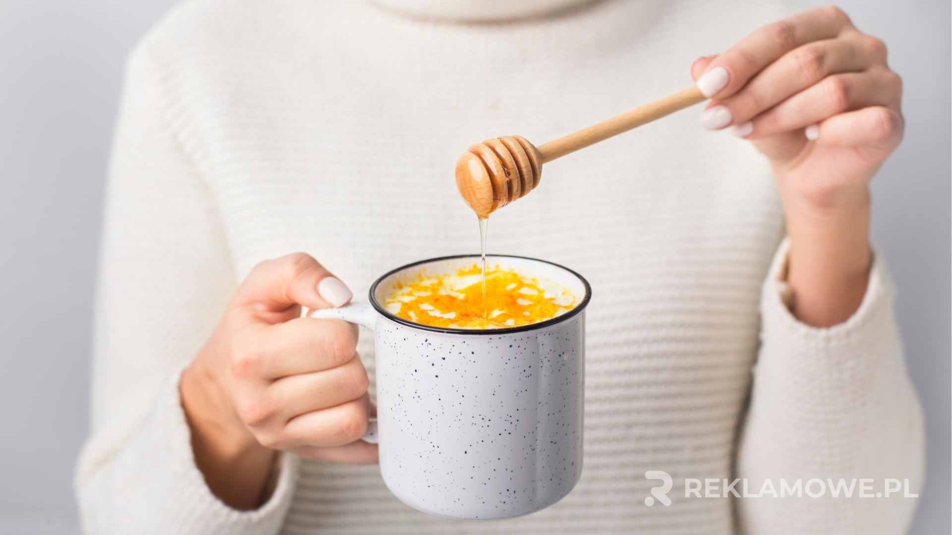 Zadbany sweter reklamowy na drewnianym wieszaku